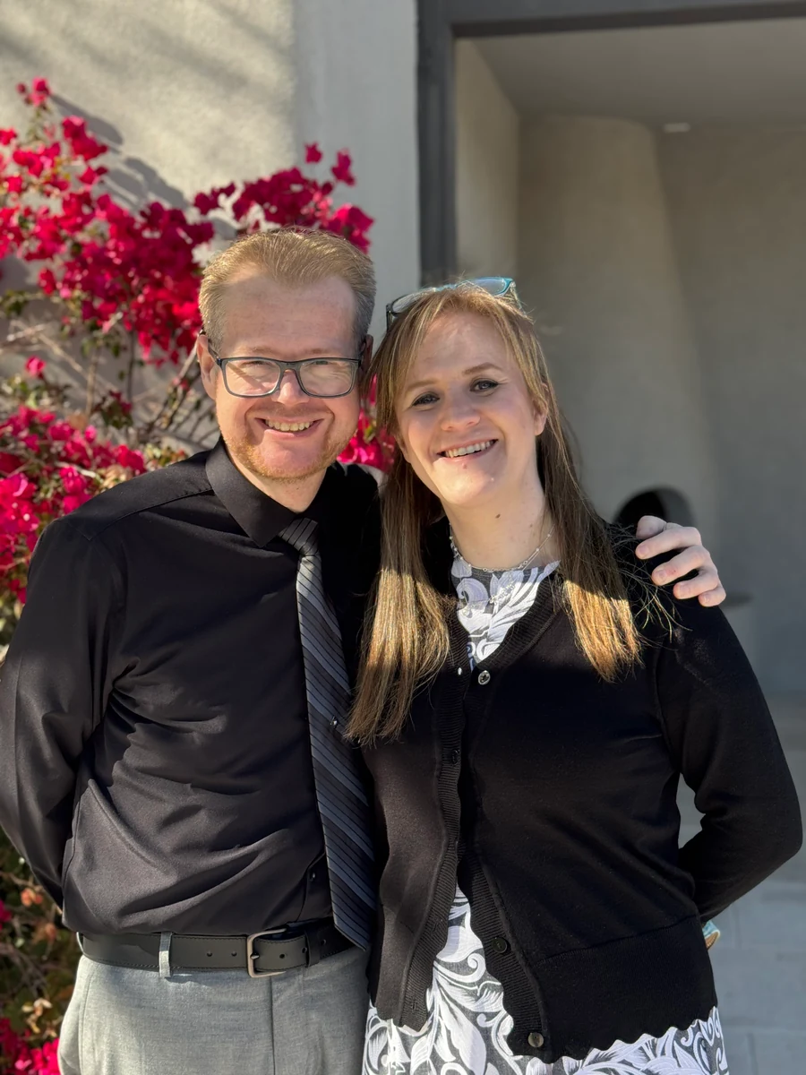 Sandra and David together outdoors by pink flowers